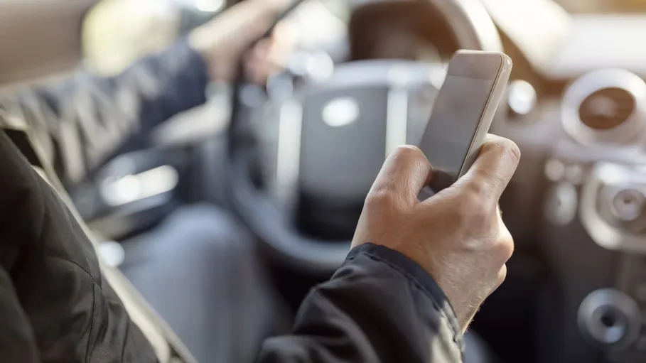 A driver holding a phone while at the wheel
