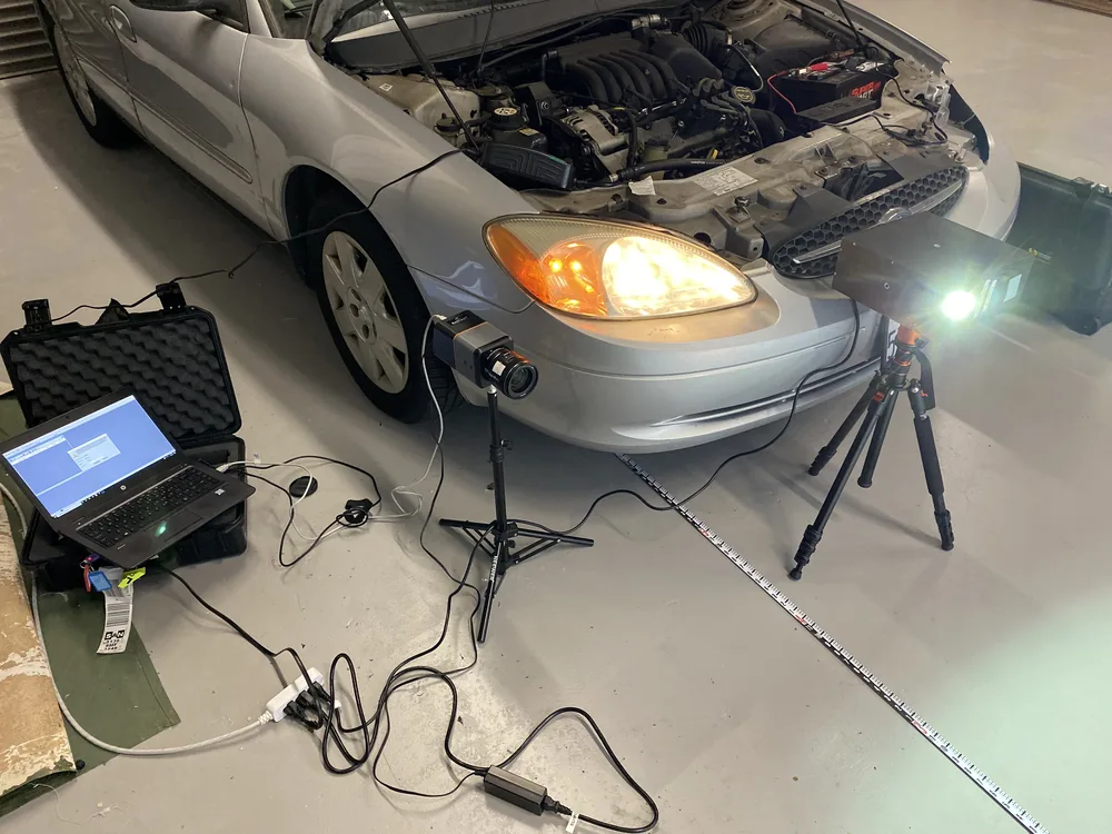 Test equipment connected to a car with its hood open at night