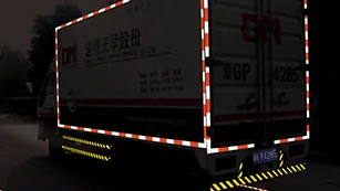 The rear of a trailer at night, outlined by retroreflective tape