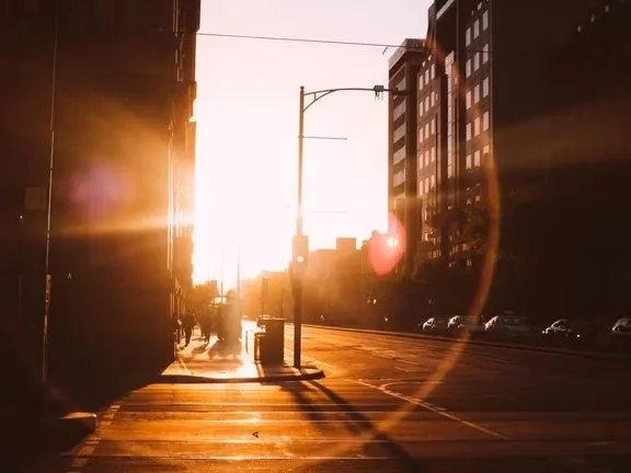 A street at dusk with the sun low on the horizon